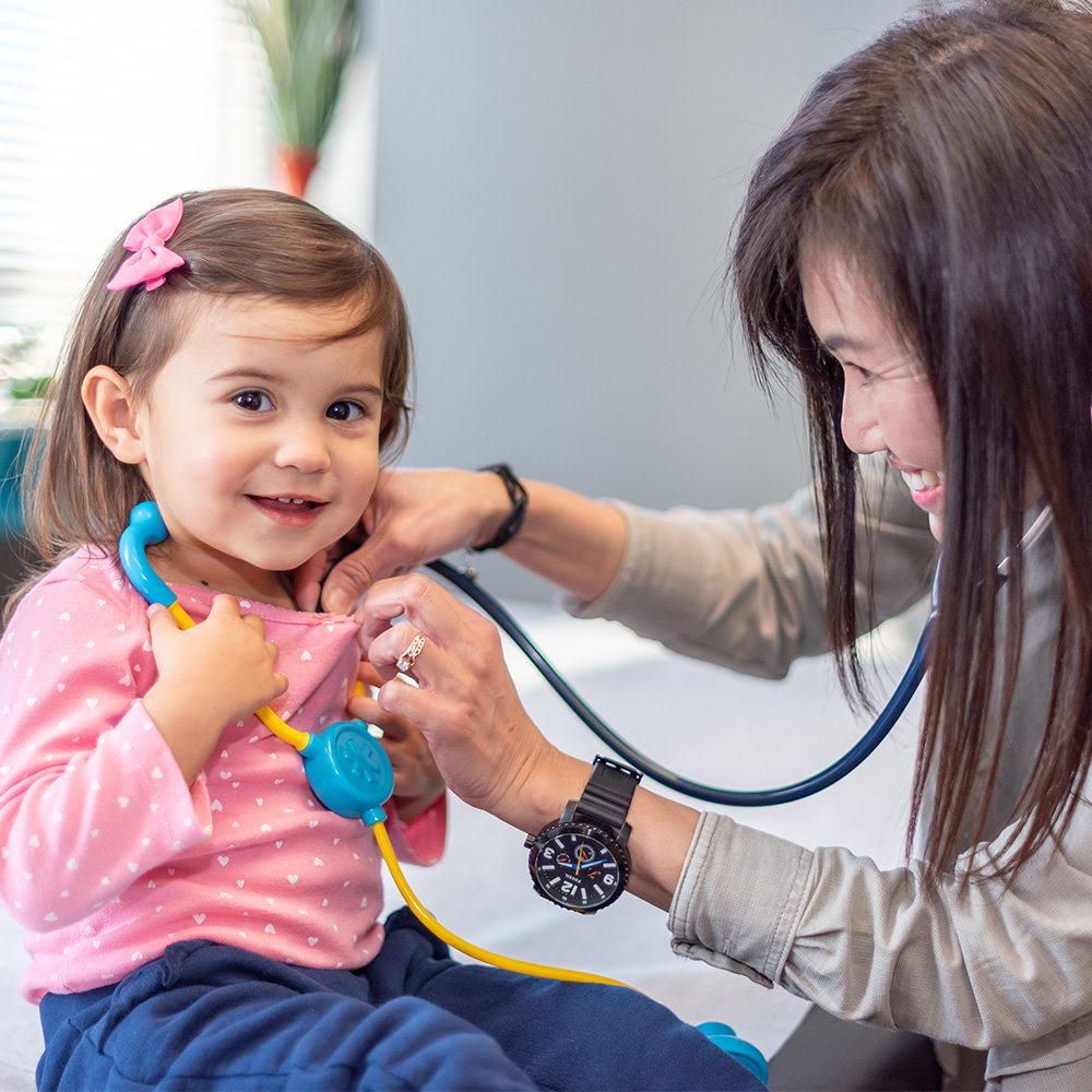 Pediatrician seeing a patient who is wearing a toy stethoscope